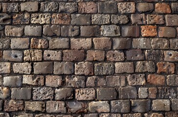 Naklejka premium A brick wall featuring a variety of different colored bricks arranged in a visually striking pattern