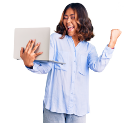 Young beautiful mixed race woman working using computer laptop screaming proud, celebrating victory and success very excited with raised arms