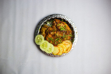 Spicy Chicken chaap with tomato and cucumber served in plate isolated on background top view of bangladeshi, indian and pakistani traditional spicy food
