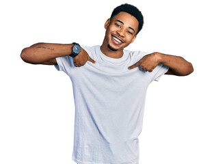 Young african american man wearing casual white t shirt looking confident with smile on face,...