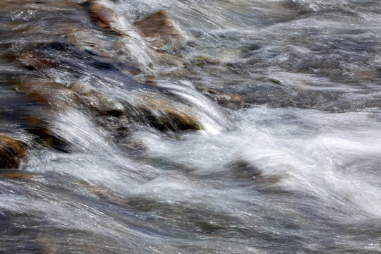 Long exposure photography of water flowing over rocks, abstract landscape photo. 