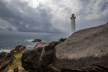 Le Phare du Vieux-Fort, white lighthouse on a cliff. Dramatic clouds overlooking the sea. Pure Caribbean on Guadeloupe, French Antilles, France - obrazy, fototapety, plakaty