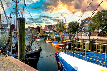 Traditional harbour scene with fishing boats in Neuharlingersiel at sunset, Nordesee, Germany