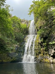 Fototapeta na wymiar waterfall falling into a small lake in the mountains