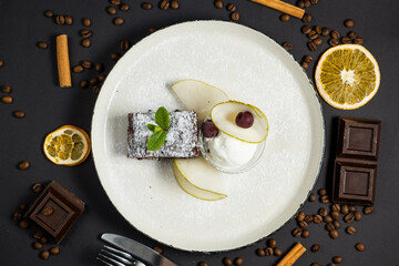 Brownie in plate with ice cream on black background
