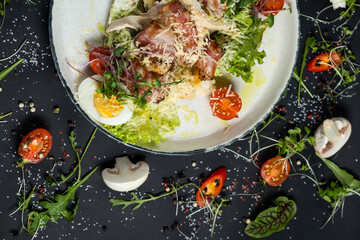 Fresh caesar salad in white plate on dark wooden table. Top view.