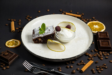 Brownie in plate with ice cream on black background
