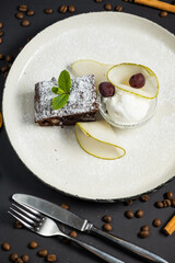Brownie in plate with ice cream on black background