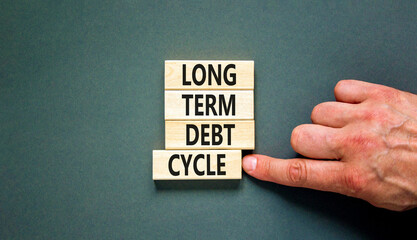 Long term debt cycle symbol. Concept words Long term debt cycle on beautiful wooden block. Beautiful grey table grey background. Businessman hand. Business Long term debt cycle concept. Copy space.