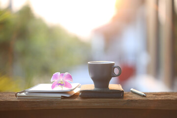 Books with flowers and cup on wooden table