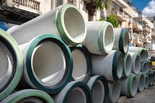 Concrete drainage pipes stacked on the street on construction site. Tel Aviv, Israel.