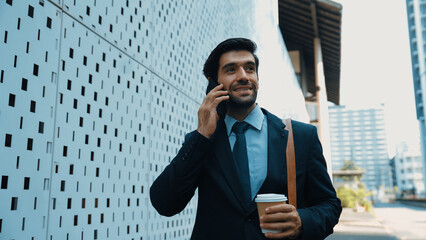 Smart business man using phone to talking about business investment. Happy manager walking at...