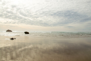 Fototapeta na wymiar Dusk Reflections: Overcast Beach