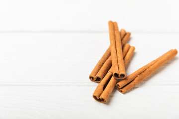 Cinnamon sticks on a textured wooden background. Cinnamon roll. Spicy spice for baking, desserts and drinks. Fragrant ground cinnamon. cinnamon powder Close-up. Place for text. copy space