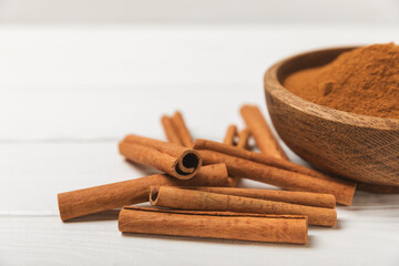 Cinnamon sticks on a textured wooden background. Cinnamon roll. Spicy spice for baking, desserts and drinks. Fragrant ground cinnamon. cinnamon powder Close-up. Place for text. copy space