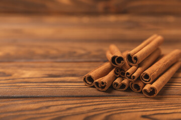 Cinnamon sticks on a textured wooden background. Cinnamon roll. Spicy spice for baking, desserts and drinks. Fragrant ground cinnamon. cinnamon powder Close-up. Place for text. copy space