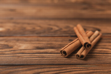 Cinnamon sticks on a textured wooden background. Cinnamon roll. Spicy spice for baking, desserts and drinks. Fragrant ground cinnamon. cinnamon powder Close-up. Place for text. copy space
