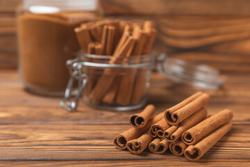 Cinnamon sticks on a textured wooden background. Cinnamon roll. Spicy spice for baking, desserts and drinks. Fragrant ground cinnamon. cinnamon powder Close-up. Place for text. copy space