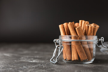 Cinnamon sticks on a textured wooden background. Cinnamon roll. Spicy spice for baking, desserts and drinks. Fragrant ground cinnamon. cinnamon powder Close-up. Place for text. copy space