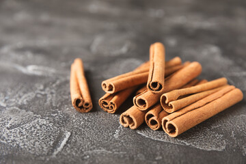 Cinnamon sticks on a textured wooden background. Cinnamon roll. Spicy spice for baking, desserts and drinks. Fragrant ground cinnamon. cinnamon powder Close-up. Place for text. copy space