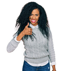 Middle age african american woman wearing casual clothes doing happy thumbs up gesture with hand....