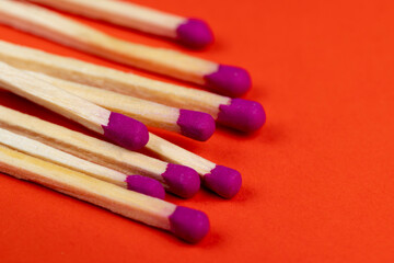 matches with a red pink substance for lighting on an orange background