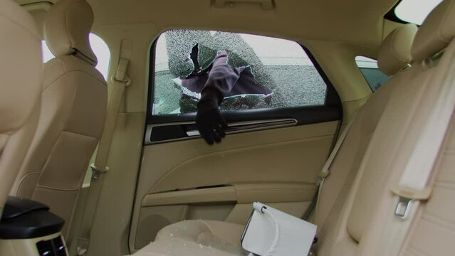 Criminal carjacker shatters car window to gain illicit entry. Carjacker methodical strike breaks calm shattered car window With precision and determination thief breaches vehicle's security.