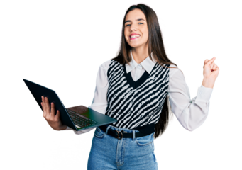 Young brunette teenager working using computer laptop screaming proud, celebrating victory and success very excited with raised arm