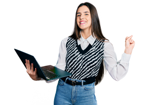 Young brunette teenager working using computer laptop screaming proud, celebrating victory and success very excited with raised arm