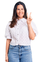 Young beautiful brunette woman wearing casual shirt showing and pointing up with fingers number two while smiling confident and happy.