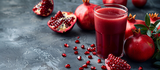 Fresh raw pomegranate juice glass. Ripe pomegranate juicy fruit and seeds on background. Healthy sweet drink.