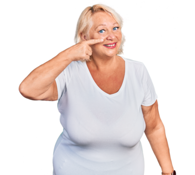 Middle age blonde woman wearing casual white t shirt pointing with hand finger to face and nose, smiling cheerful. beauty concept