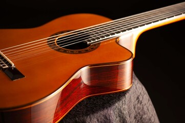 Classical Spanish flamenco guitar close up, dramatically lit isolated on black background with copy...
