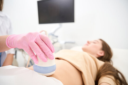Focus of ultrasound scanning of woman pregnant belly doing female gynecologist