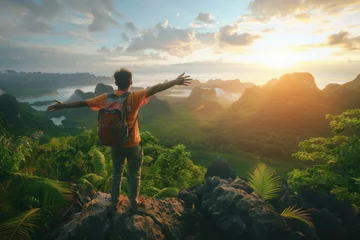 Fotobehang Tourist athlete rejoices climbing a mountain in a tropical country, success and goal achievement concept, man raised his hands up in delight © Henryzoom