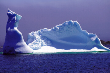 Large iceberg near the shore on a calm sea under in early summer