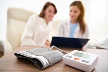 Tonometer on table with blurred background of female patient and doctor