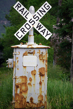 Railway crossing sign on a rusty post in rural Newfoundland