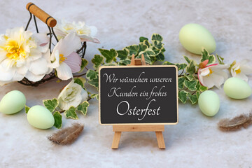 Grußkarte Frohe Ostern: Blumen mit Ostereiern und der Beschriftung wir wünschen ein frohes...