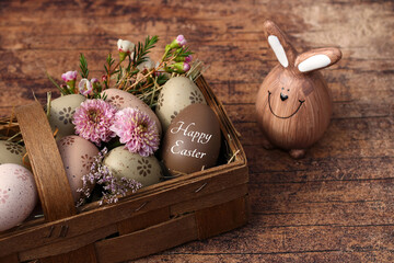 Greeting card Happy Easter: Basket with Easter eggs on shabby wooden board with the text Happy...