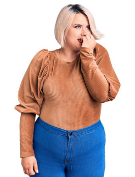 Young blonde plus size woman wearing casual sweater looking stressed and nervous with hands on mouth biting nails. anxiety problem.