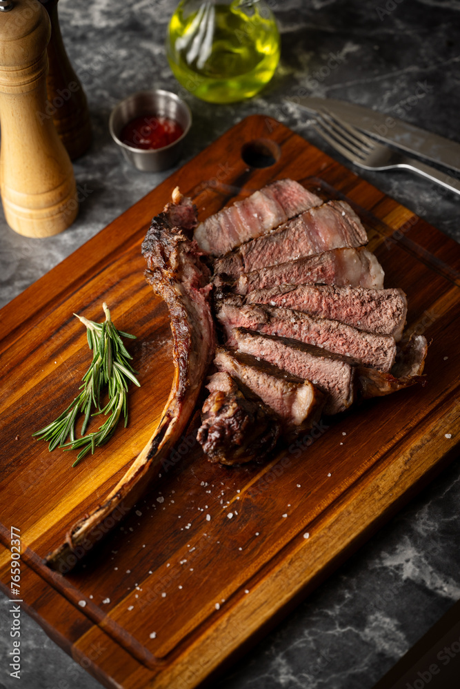 Poster sliced tomahawk steak on wooden board