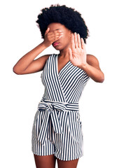 Young african american woman wearing casual clothes covering eyes with hands and doing stop gesture with sad and fear expression. embarrassed and negative concept.