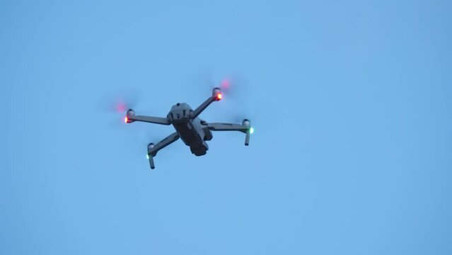 Military drone in flight observing positions at twilight sky, slow motion