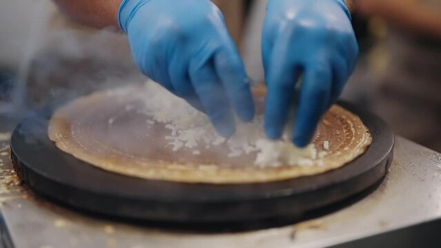 Making of crepes pancakes in open market festival fair, slow motion
