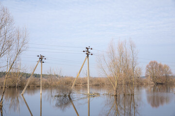 The flood of the river in the spring. The poles with electric poles are flooded. The flood.