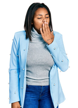 Beautiful hispanic woman wearing business jacket bored yawning tired covering mouth with hand. restless and sleepiness.