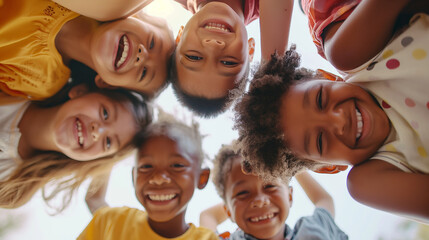 A vibrant group of children from diverse backgrounds gathered in a sunlit health center lobby, huddled together in a circle, their laughter and joy captured as they look down at th - obrazy, fototapety, plakaty
