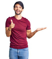 Handsome hispanic man wearing casual clothes showing palm hand and doing ok gesture with thumbs up, smiling happy and cheerful