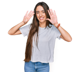 Young hispanic girl wearing casual white t shirt showing and pointing up with fingers number nine while smiling confident and happy.